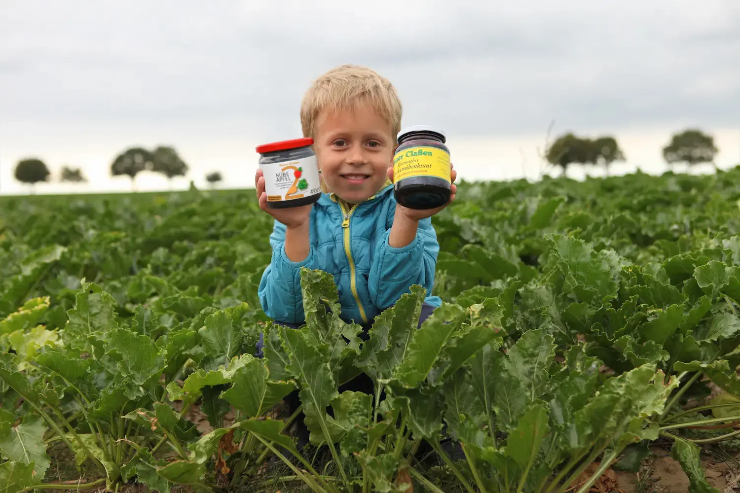 Kind hält Zuckerrübenkraut und RÜBE APFEL hoch