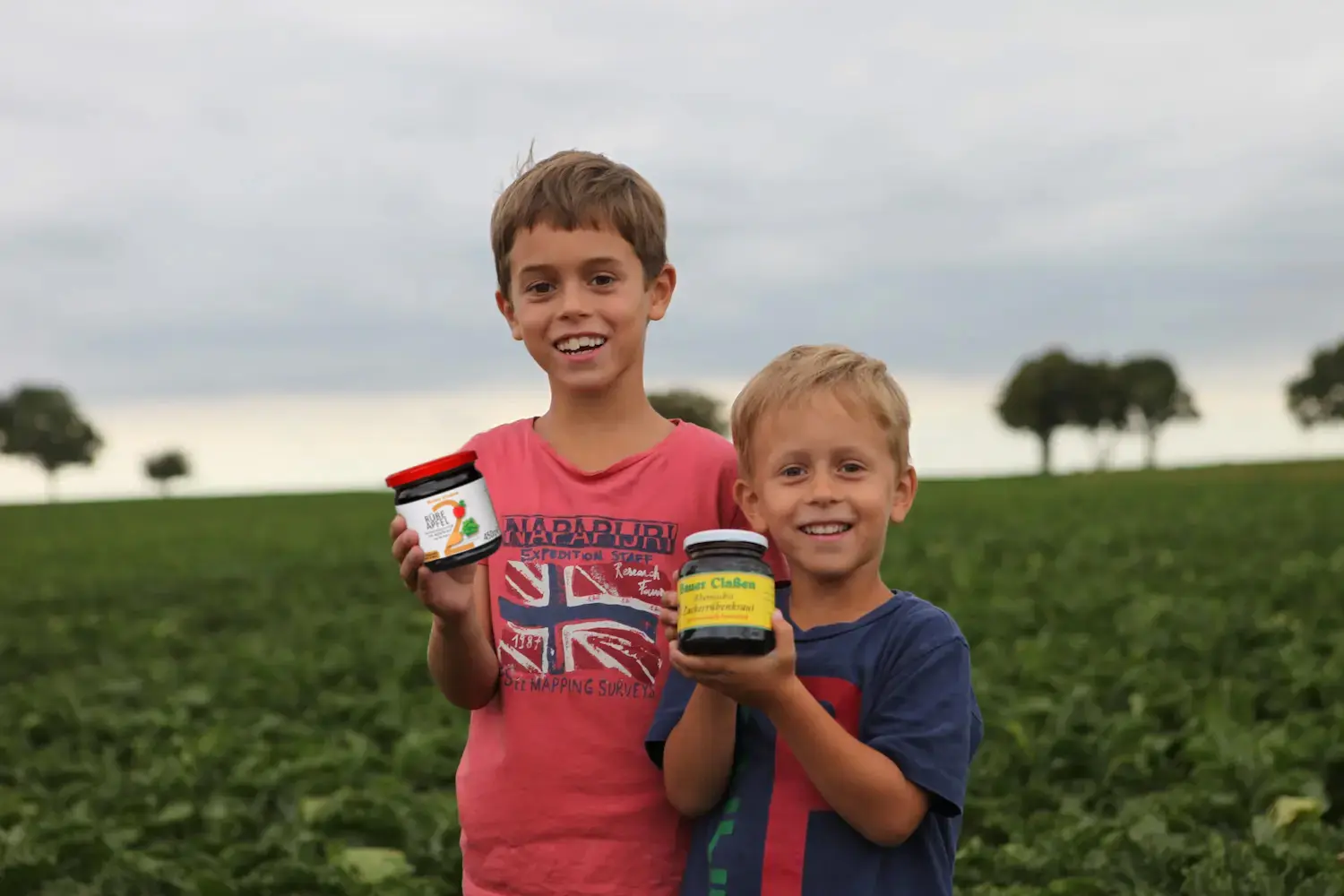 Kinder halten Zuckerrübenkraut und RÜBE APFEL hoch